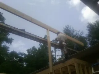 Carpenter setting a ridge beam over a new addition frame — Ice Dam Removal by Roofing Brothers in Oakpark