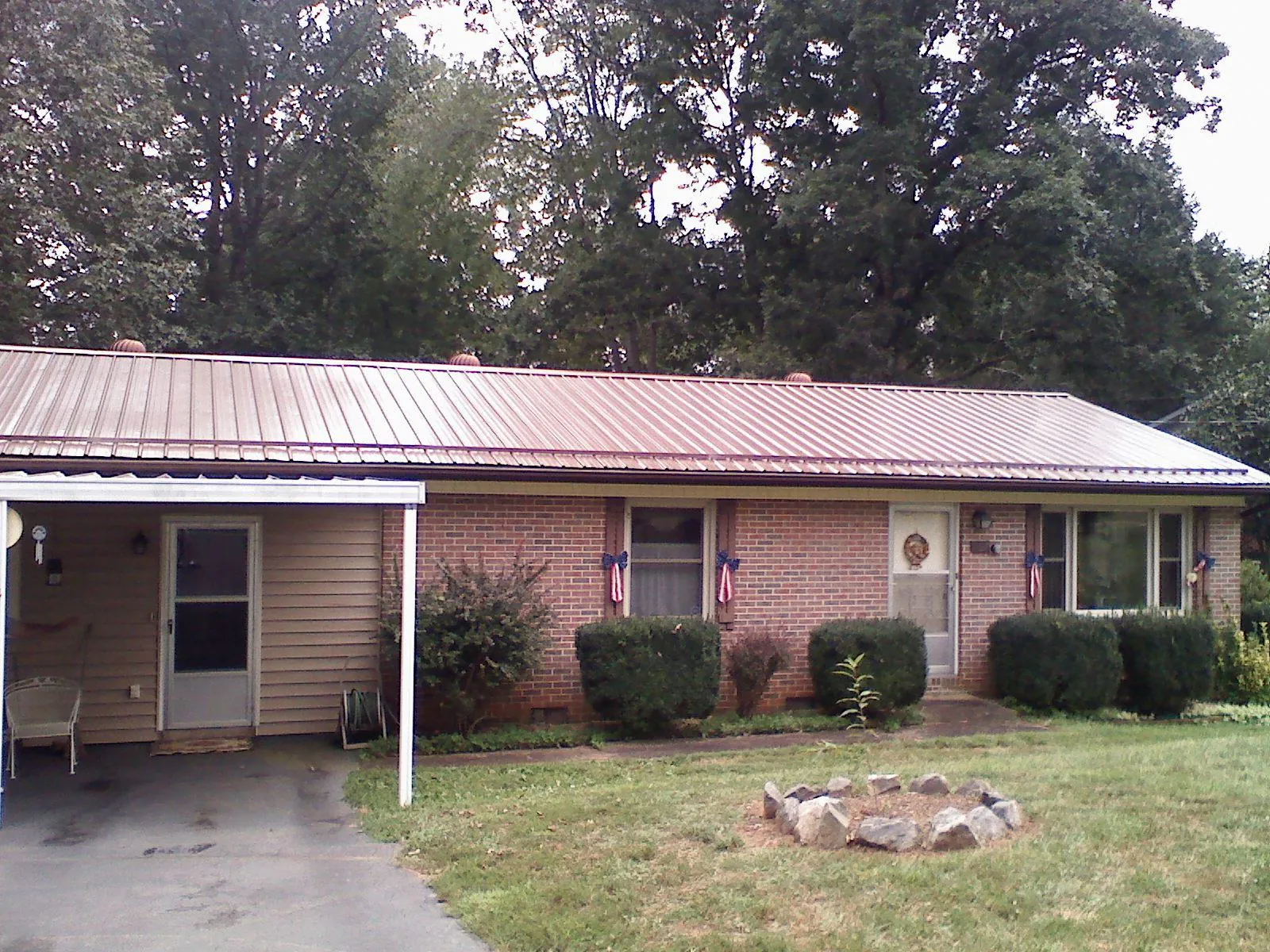 Bronze metal roof and carport on a brick ranch home — Roof Repair work by our crew in Oakpark